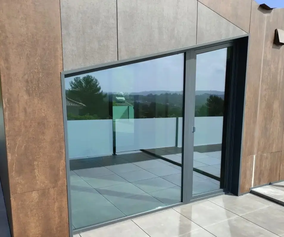 Porta de correr em PVC com painel fixo envidraçado numa moradia